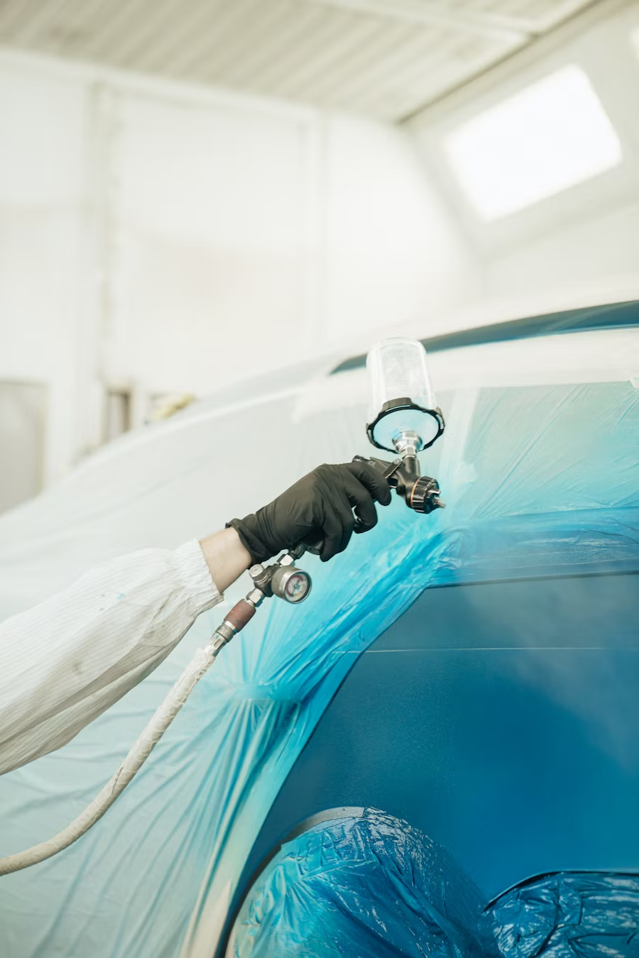 A person sprays a car.
