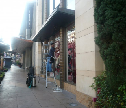 A person applies film to a commercial window. 