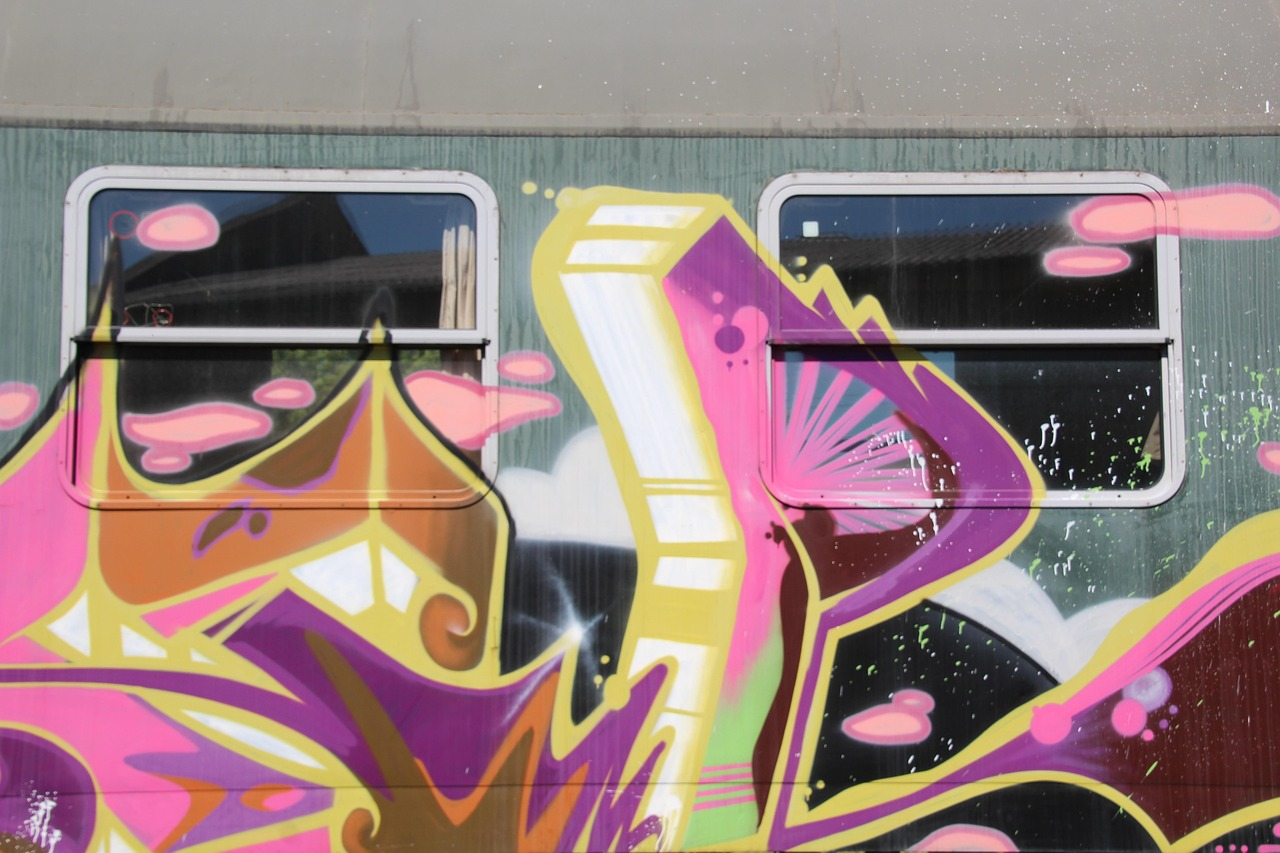 A wall and windows with graffiti on them.