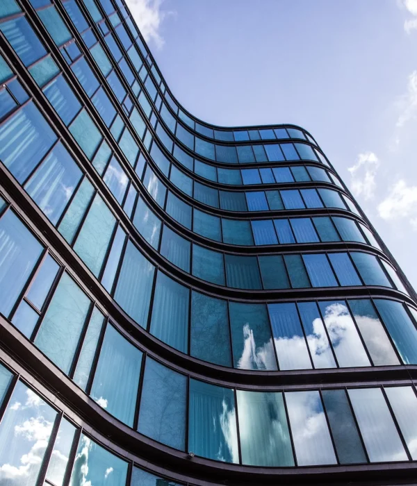high rise building glass facade with reflection surrounding buildings