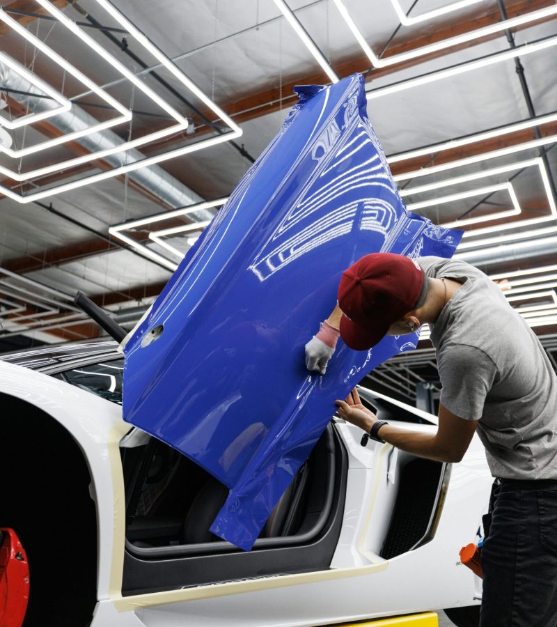 technician applying automotive window tinting film on white car scaled
